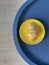 Top view on yellow plate with fresh croissant on round blue table with white wooden floor as background. Mobile photo