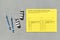 Top view of yellow vaccination record card, syringes, and two vials of the COVID-19 vaccine for two-stage injection