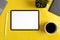 Top view of a yellow work surface with mockup tablet, plant and coffee