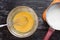 Top view of yolks, starch and sugar mix in bowl as ingredient to make custard cream on the black background