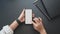 Top view of young businesswoman touching blank screen smartphone in dark luxury workspace