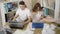 Top view of young caucasian man and woman in dirty t-shirts sitting with pizza and typing on laptop keyboards. Couple of