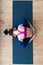 Top view of young Caucasian woman sitting in sleeping tortoise pose supta kurmasana on floor in studio