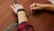 Top view young craftsman makes a line of markings on the leather cloth using a ruler. Handmade leather manufactures