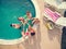 Top view of young girls and boys in swimming pool toasting with