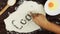 Top view Young man writes a word cook on white flour at wooden desk from above.