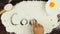 Top view Young man writes a word cook on white flour at wooden desk from above.