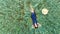 Top view of young woman in a dress relaxing on the wheat field