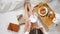 Top view on young woman Legs In cosy bed with white beddings: cup of coffee in hands, Laptop, table tray with Breakfast