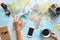 Top view of young woman planning her vacation using world map while drinking coffee - Tourist pointing the next travel destination