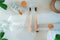 Top view zero waste bathroom items. Bamboo toothbrushes, natural mouthwashing tabs, fresh green leaves and glass of