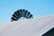 Top of a windmill over the corrugated roof of a shearing shed