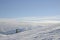 On top of the world. The skier goes to the top of the mountain. Above the clouds