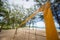 Top of yellow voleyball net on beach among palm trees