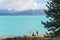 THE TOPAZ BLUE WATER AND SNOW CAPPED MOUNTAIN PEAKS OF LAKE PUKAKI ATTRACT THOUSANDS YEARLY
