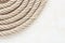 Topdown view of coiled rope on clean white surface