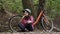 Topic ecological bicycle transport. Young caucasian woman in jeans and shirt student sits resting in park near rental