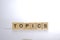 TOPICS - word of wooden blocks with a letter on white background