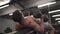 Topless Asian muscular man on workout weight bench lifting heavy dumbbell at gym. male bodybuilder put effort training torso muscl