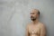 Topless bald beard portrait of adult man with grey cement wall background