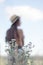 topless brunette woman in straw hat in the field