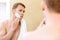 Topless man applying mean of shaving on face