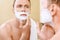 Topless man applying mean of shaving on face