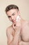 Topless man applying mean of shaving on face