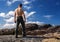 Topless strong man stands on the mountain