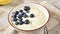 Topping bowl of yogurt with blueberries and almonds