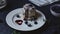 Topping with powdered sugarJapanese soft pancakes with blueberries, hot chocolate on a round white plate. Cotton light napkin on a