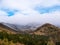 Tops of mountains in low thick clouds and trees covered with hoarfrost, morning hills panorama