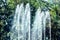 The tops of the water fountains of the city park.