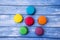 Topshot of sweet and colourful french macaroons on blue wooden
