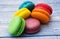 Topshot of sweet and colourful french macaroons on blue wooden