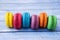 Topshot of sweet and colourful french macaroons on blue wooden background