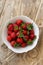 Topview image of strawberries in a white rustic bowl