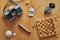 Topview of vintage travel equipment on a wooden table. Retro camera, matches, knife, mussel, chess board and compass on a wooden