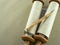 Torah scrolls on a wooden table close-up on a background of gray linen canvas.