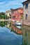 Torcello, Venice. Colorful houses on Torcello island, canal and boats. Italy