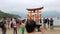 Tori gate at sea on Miyajima, Hiroshima, people around