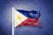 Torn flag of Philippines flying against grunge background