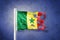 Torn flag of Senegal flying against grunge background