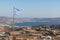 Torn Greek flag with  Adamas village in background