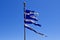 Torn Greek Flag Against Blue Sky