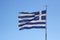 Torn Greek flag on blue background