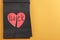 Torn heart and word LUCK written in notebook on orange background. Space for text