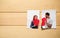 Torn photo of happy couple on wooden background. Concept of divorce