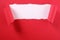 Torn red paper strip curled edge revealing white background open curtain