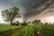 tornado barreling toward farmhouse, with stormchaser in pursuit